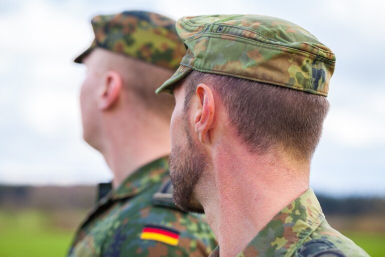 Zwei deutsche Soldaten in Uniform schauen zur Seite.