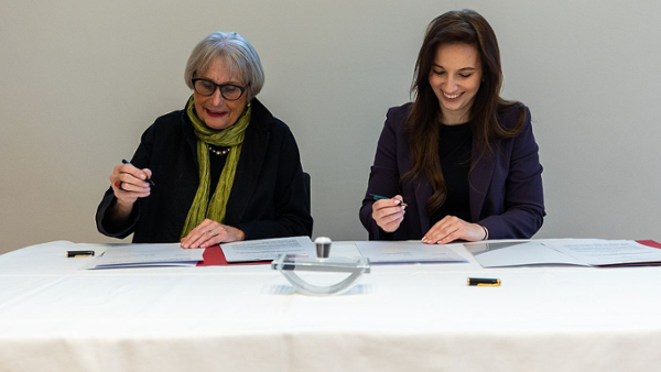Zwei Frauen unterschreiben Verträge.