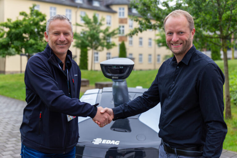 Gerhard Körbel von der EDAG Group , links im Bild, übergibt den EDAG CityBot an Professor Martin Kumm von der Hochschule Fulda