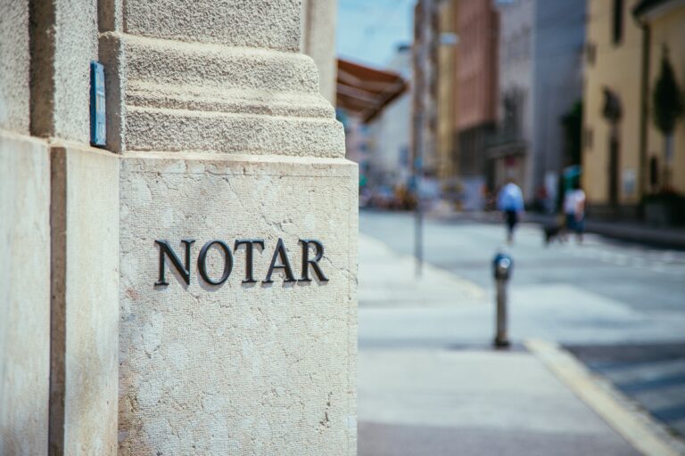 Das Bild zeigt den Eingang zu einem Notariat mit dem Schriftzug Notar auf einer Steineinfassung.