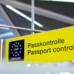 Gelbes Schild mit der aufschrift Passkontrolle/Passport Control