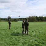 Außenaufnahme: Wiese mit mehreren Männern in Uniform, auf dem Boden eine weiße Markierung.