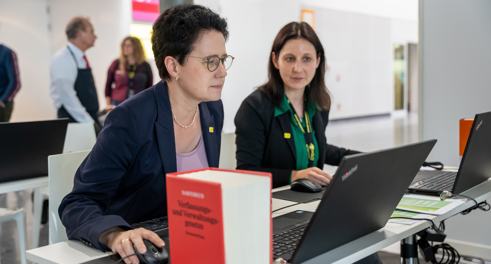 Die Ministerin der Justiz und für Migration Marion Gentges (links) beim Test der Hard- und Software auf der Landesmesse in Stuttgart.