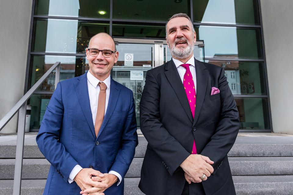 Staatssekretär Torsten Weil und Digitalminister Steffen Schütz stehen gemeinsam auf den Stufen vor dem Ministerium.