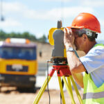 Landvermesser mit Theodolit auf einer Baustelle